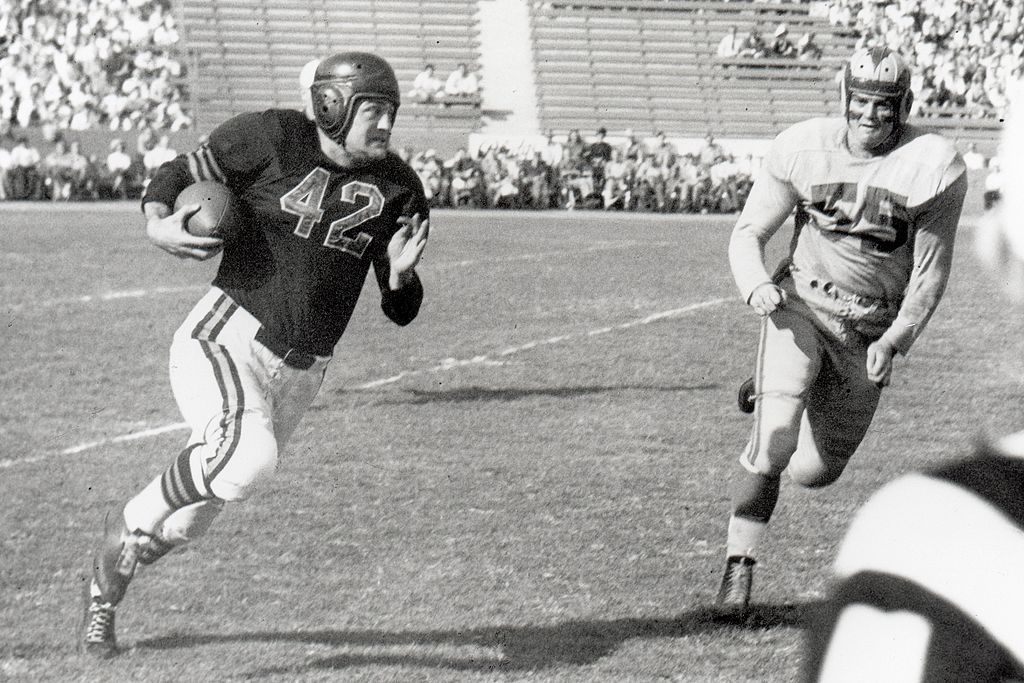 LOS ANGELES - NOVEMBER 7:  Quarterback Sid Luckman #42 of the Chicago Bears runs past end Tom Fears #55 of the Los Angeles Rams during a game played on November 7, 1948 at the Los Angeles Coliseum in Los Angeles, California. (Photo by Vic Stein /Getty Images)